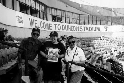 04-12-01-5
 Earl and Carrie Scott of Dunedin, FL pose with Jennifer Scott (center) of Mattapoisett during a recent visit to Dunedin Stadium, where the Toronto Blue Jays conduct their winter training camps. The Blue Jays were playing the Boston Red Sox this particular day. (Photo courtesy of Jennifer Scott.) 4/12/01 edition

