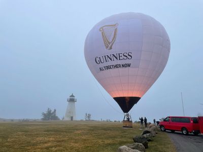 Ned's Point Balloon
Not a typical Saturday morning at Ned’s Point, where the Guinness promotional team finished up a St. Patrick's Day city tour that included Chicago, the Guinness brewery outside Baltimore, and New York before concluding in Mattapoisett. “The backdrop is gorgeous, the setting is another reason,” said Jeremy Hoar of the choice to use Ned’s Point as the Massachusetts location. Hoar, who works for public-relations company MKTG, said that SkyCab Balloons Promotions, Inc. Photo courtesy of Faith Ball

