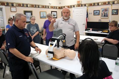 CPR Class
May Caron, 19, of Marion demonstrates a sound CPR form on a manikin, while New Bedford EMS trainer David Branco explains the practice during a September 21 class held at the Rochester Senior Center under the direction of the Rochester Fire Department. Branco and David Zander also demonstrated the use of a battery-operated, $15,000 CPR machine that last month was used during a cardiac event to save the life of Rochester Fire Chief Scott Weigel
