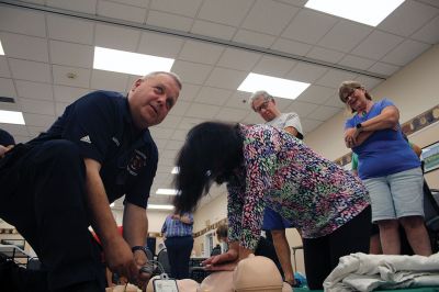 CPR Class
May Caron, 19, of Marion demonstrates a sound CPR form on a manikin, while New Bedford EMS trainer David Branco explains the practice during a September 21 class held at the Rochester Senior Center under the direction of the Rochester Fire Department. Branco and David Zander also demonstrated the use of a battery-operated, $15,000 CPR machine that last month was used during a cardiac event to save the life of Rochester Fire Chief Scott Weigel
