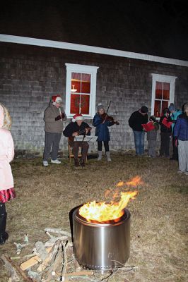 Tinkhamtown Chapel Christmas Carol Singalong
Sunday's participants in the Tinkhamtown Chapel Christmas Carol Singalong braved a dramatic, postsunset drop in temperature and enjoyed the warmth of a solo bonfire loaned to the event by Lee Heald. Gail Roberts led distributed sheet music and led in song with musicians Louise Anthony playing the fiddle and Jack Dean the ukulele. Roberts thanked the White family for providing refreshments, the Chapel committee for its effort in maintaining the chapel 
