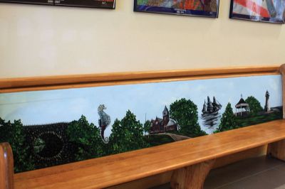 Center School Donation
An antique church pew gifted to Center School by James and Roxanne Bungert features a painted depiction of landmarks throughout Mattapoisett, including the school. Photo by Marilou Newell

