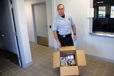 Drug Take Back Day
Capt. Anthony Days of the Mattapoisett Police Department stands with a box full of old prescription medication, collected in the first half hour of National Drug Take Back Day, Saturday, April 28, 2012. The national program coordinates local police with the Drug Enforcement Agency to offer citizens a chance to turn in their old and unused prescription medications for safe disposal.  The Mattapoisett Police collected over 1000 prescriptions, according to Captain Days. Photo by Eric Tripoli

