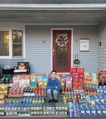 Davin Alves
Davin Alves, a 10-year-old Sippican Elementary School student, sits at his Marion home in front of items he bought with $900 he raised by raffling off two video games, a $100 gift card and a bottle of scotch, all to meet the needs of people struggling during the holidays. The food he purchased in bulk is being donated to United Way of Greater New Bedford Hunger Commission. Photo courtesy of Kathylee Alves

