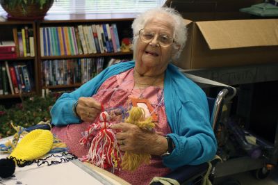 Doll Lady
Antoinette (Toni) Boissoneau, a resident of Sippican Health Center in Marion, makes yarn dolls for area families. Her yarn dolls have delighted many children visitors, and have even been donated to St. Jude's Hospital. Ms. Boissoneau is looking for yarn donations, especially bright yarn. If you are interested in donating, please call the Sippican Health Center at 508-748-3830. Photo by Laura Fedak Pedulli.
