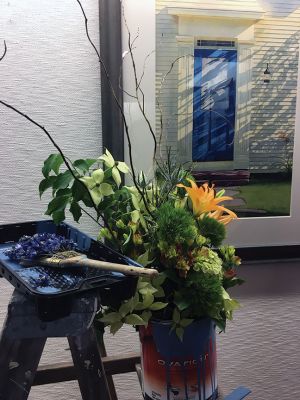 Marion Art Center
A blue can of paint becomes the blue door and the paint brush surprises in Diane Kelley’s floral arrangement inspired by Peter Hussey’s “Screen Door With Lily” painting. Photo by Marilou Newell.
