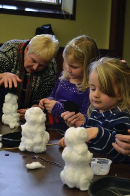 Build-your-own Snowman
Under the direction of Jeanne McCullough, children at the Mattapoisett Free Library on December 30 participated in a step-by-step build-your-own snowperson activity during the winter school break. Little fingers sticky with glue flattened out cotton balls and fastened them to prefabricated Styrofoam snowperson shapes, and then glued on the trimmings under the guidance of caregivers. Photos by Jean Perry
