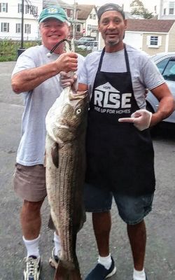 Striped Bass
“East End” Eddie Doherty of Mattapoisett (left) is shown donating a fresh 30-pound striped bass caught at the canal to the Sister Rose House in New Bedford. Accepting the fish is long-time chef Luke. Photo courtesy of Joanne Doherty.
