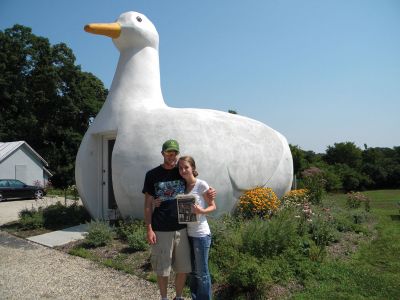 One Big Duck
Hayley Bentz and Ian MacGregor of Rochester recently took a trip to Long Island, New York. They took a moment to pose with a copy of The Wanderer in front of the Big Duck in Flanders, NY. The Big Duck, built to be a store by Martin Maurer in 1931, is a famous landmark in Long Island, and is on the national registry of historic places. Photo courtesy of Hayley Bentz.
