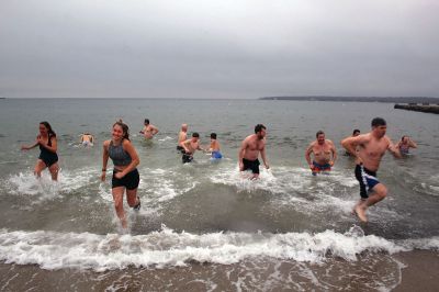 Christmas Swim
Kate Butler was last to arrive but last one out of the water after two dozen people braved the cold, raw elements of the 2021 Christmas morning swim held December 25 at Mattapoisett Town Beach. The event was held for the benefit of Helping Hands and Hooves, a program run by Julie Craig and Debbie Dyson that offers experiences, especially horseback riding, to people with cognitive challenges who have aged out of the many children's programs. Photos by Mick Colageo
