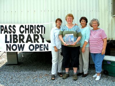 Lena at the Library
Rochester resident Lena Bourque (second from left, holding a copy of The Wanderer), poses with (l. to r.) Jan Delaune, Jerry Sellier, and Library Director Sally James. Ms. Bourque was recently involved with the rebuilding and reopening of the Pass Christian Public Library in Pass Christian, Mississippi, while her husband was involved in a bridge reconstruction project. (Photo courtesy of Lena Bourque).
