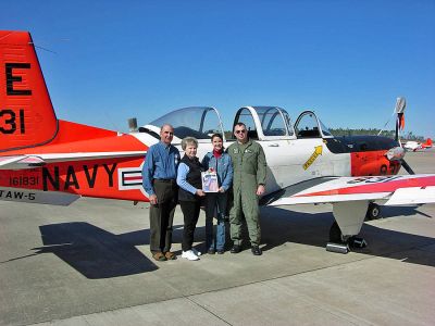 Learning to Fly
Tony and Diane Lopes pose with their daughter Heather and her husband Lieutenant Josh Shultz in front of Joshs T34 training plane with a copy of The Wanderer at the Naval Air Station in Pensacola where he is training to be a Naval Aviator.
