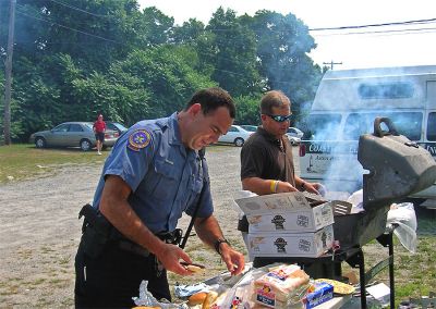 Police Grilling
Mattapoisett Police Officers Anthony Days (foreground) and Mitch Suzan (background) grill up some tasty hot dogs and hamburgers for the town seniors during the annual Senior Picnic sponsored by the Friends of the Elderly which was held on Thursday, August 16 at the Knights of Columbus facility on Route 6. (Photo by Eileen J. Marum).
