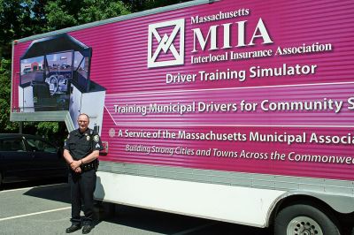 Driving Force
Rochester Police Sergeant William Chamberlain poses outside the Emergency Driving Training Simulator unit sponsored by the Massachusetts Interlocal Insurance Agency (MIIA) which was stationed outside the Rochester Police Department this past week to help train town public safety personnel in proper high-speed driving techniques. (Photo by Robert Chiarito).
