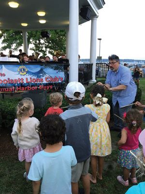 Mattapoisett Town Band
Mattapoisett Band Director Jayson Newell shows the children how to conduct a band. Little ones were each loaned a baton to give the band the downbeat during the July 12 concert. Photo by Marilou Newell
