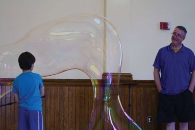 Bubbles, bubbles, everywhere! 
Kids were spellbound by Keith Johnson and his “Bubbleology” show at the Marion Music Hall on June 22, sponsored by the Elizabeth Taber Library. Ty Mackenzie, 9, was the lucky one who got to be swallowed up by a giant bubble. Photos by Jean Perry
