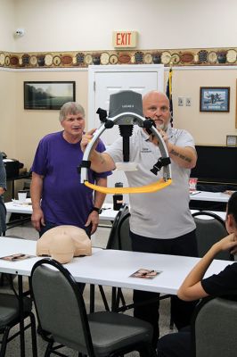 CPR Class
May Caron, 19, of Marion demonstrates a sound CPR form on a manikin, while New Bedford EMS trainer David Branco explains the practice during a September 21 class held at the Rochester Senior Center under the direction of the Rochester Fire Department. Branco and David Zander also demonstrated the use of a battery-operated, $15,000 CPR machine that last month was used during a cardiac event to save the life of Rochester Fire Chief Scott Weigel
