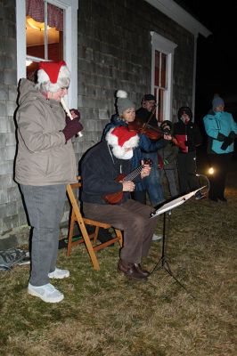 Tinkhamtown Chapel Christmas Carol Singalong
Sunday's participants in the Tinkhamtown Chapel Christmas Carol Singalong braved a dramatic, postsunset drop in temperature and enjoyed the warmth of a solo bonfire loaned to the event by Lee Heald. Gail Roberts led distributed sheet music and led in song with musicians Louise Anthony playing the fiddle and Jack Dean the ukulele. Roberts thanked the White family for providing refreshments, the Chapel committee for its effort in maintaining the chapel 
