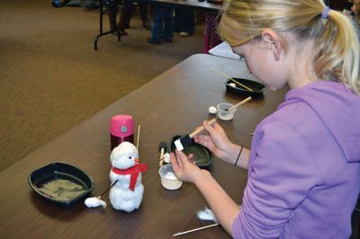 Build-your-own Snowman
Under the direction of Jeanne McCullough, children at the Mattapoisett Free Library on December 30 participated in a step-by-step build-your-own snowperson activity during the winter school break. Little fingers sticky with glue flattened out cotton balls and fastened them to prefabricated Styrofoam snowperson shapes, and then glued on the trimmings under the guidance of caregivers. Photos by Jean Perry
