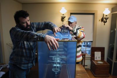 Whale Bark Wanderer
Mattapoisett Museum Curator Connor Gaudet and volunteer Bob Clifford unpack the custom model of the Whale Bark Wanderer 1878 recreated by artist George Lowery from scratch and donated to the museum. The model arrived on Tuesday afternoon from Arizona in a crate weighing a total of 181 pounds. The model joins two other models of the famous whaling ship in the museum, including a model built and donated by John D. Young. Photos by Mick Colageo
